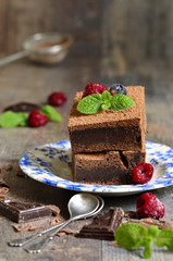 Brownies decorated with raspberry and mint leaf.