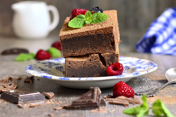 Brownies decorated with raspberry and mint leaf.