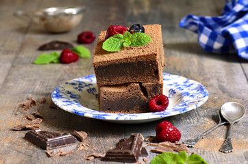 Brownies decorated with raspberry and mint leaf.