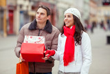 Young couple at the street holding gift boxes