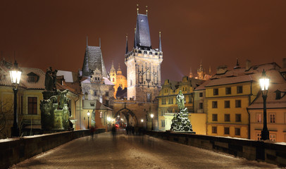 Fototapeta premium Night snowy Prague St. Nicholas' Cathedral from Charles Bridge