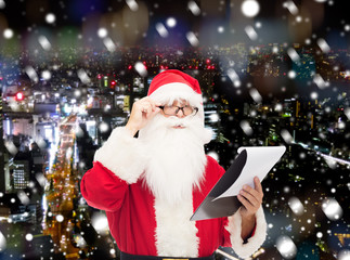 man in costume of santa claus with notepad