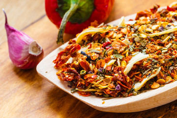 Colored spices for pasta mix on wooden spoon