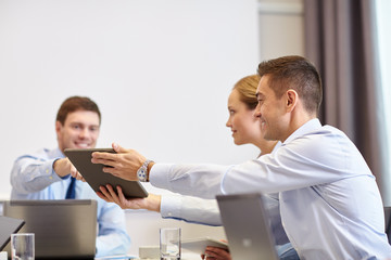 smiling business people with tablet pc in office