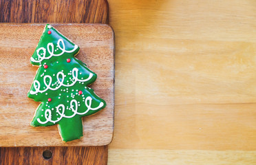 Christmas tree cookie on wood plate.
