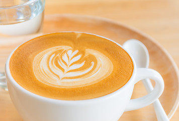 A Latte Coffee art on the wooden desk.