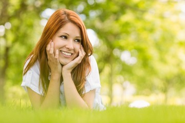 Portrait of a pretty redhead happy and lying