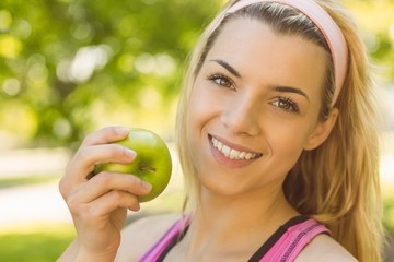 Fit blonde holding green apple