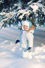 Fototapeta na wymiar Portrait of Child shakes off snow trees