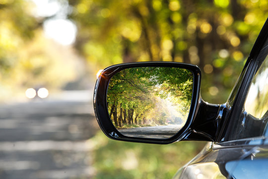 Reflection of autumn road at the rear view mirrow.