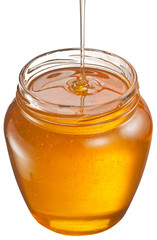 Honey flowing into glass jar. File contains clipping paths.