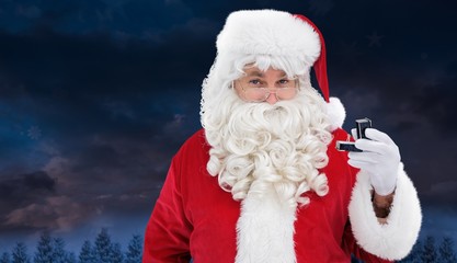 Composite image of cheerful santa holding a jewelry box