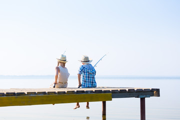 Obraz premium Boy and girl with fishing rods
