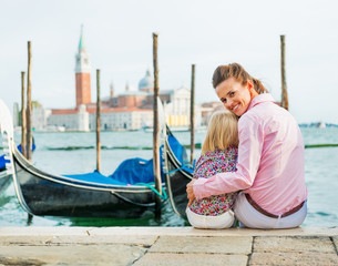 Portrait of mother and baby sitting on grand canal embankment © Alliance
