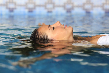 Profile of a beauty relaxed woman face floating in water