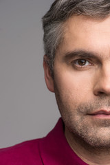 Fototapeta premium half face of adult man on grey background.