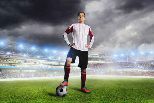 Football player with ball on field of stadium