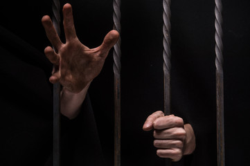 closeup on hands of man sitting in jail