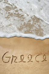 Fototapeta premium Conceptual Greece text in sand and water