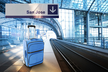Departure for San Jose. Blue suitcase at the railway station