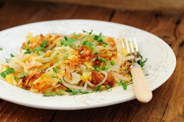 Fried potatoes on white plate with fork