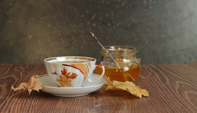 Still-life with a cup of tea, honey and autumn leaves