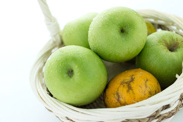 basket of green apples on white background