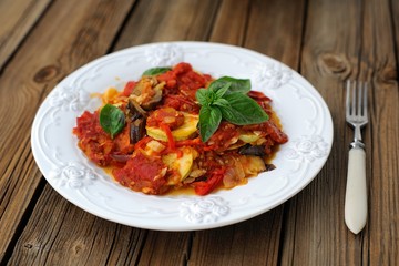 French tian with tmato, zuccini and aubergine on wooden backgrou