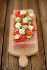 Vegetable and cheese salad served on a block on himalayan pink s