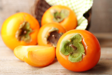 Ripe persimmons on wooden background