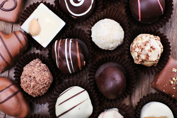 Many chocolates on wooden textured background