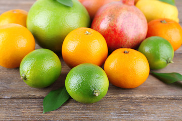 Ripe citrus with green leaves on wooden background
