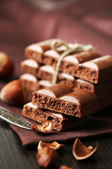 Tasty porous chocolate with nuts on table, close up