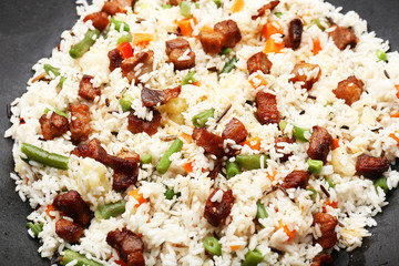 Tasty rice preparing in wok, close-up