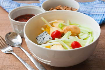 Delicious fruits salad in plate on table close-up