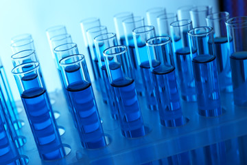 Blue water in a transparent test-tube on light background