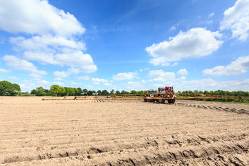 Fototapeta premium Tractor on a cultivated field in the countryside