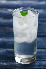 Glass with ice cubes on wooden table