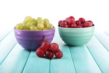 Two bowls of green and red grapes