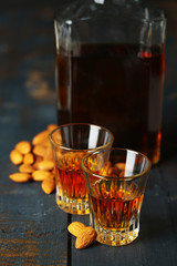 Dessert liqueur Amaretto with almond nuts, on dark wooden table