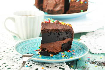 Chocolate cake with colorful sweet powder on table close-up