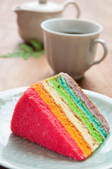 Delicious rainbow cake on plate on table