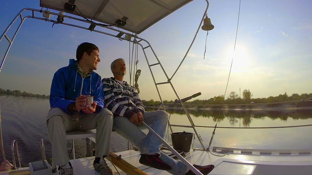 Couple of men yachting on river, friendship, hobby, tourism