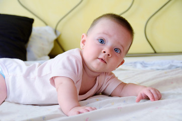 Female baby with blue eyes facing forward curiously