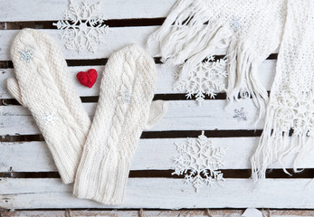 white mittens and scarf on a wooden plank background