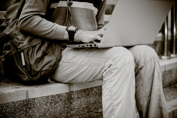 Young man using laptop on the steps