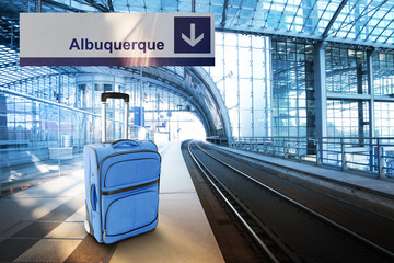 Departure for Albuquerque. Blue suitcase at the railway station