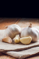 Organic garlic whole and cloves on the wooden background