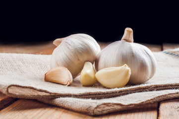 Organic garlic whole and cloves on the wooden background