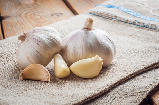Organic garlic whole and cloves on the wooden background